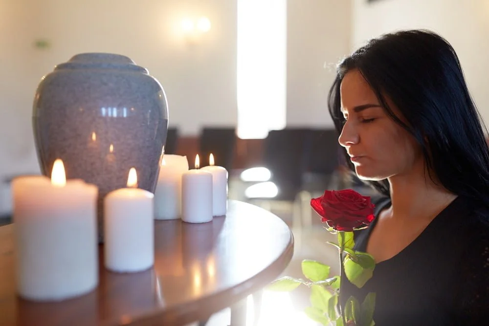 woman with roses candles and porcelain urn at church